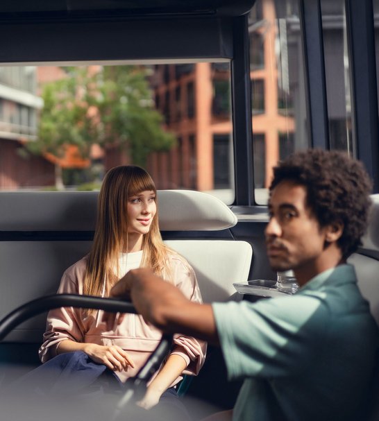 [Translate to Deutsch:] the interior of the mover with two passengers sitting 